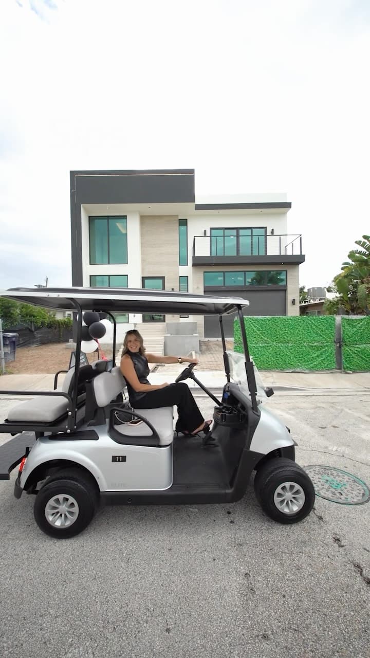 Jessica Sonino in a golf cart outside the new modern home at 7516 Bounty Ave, North Bay Village