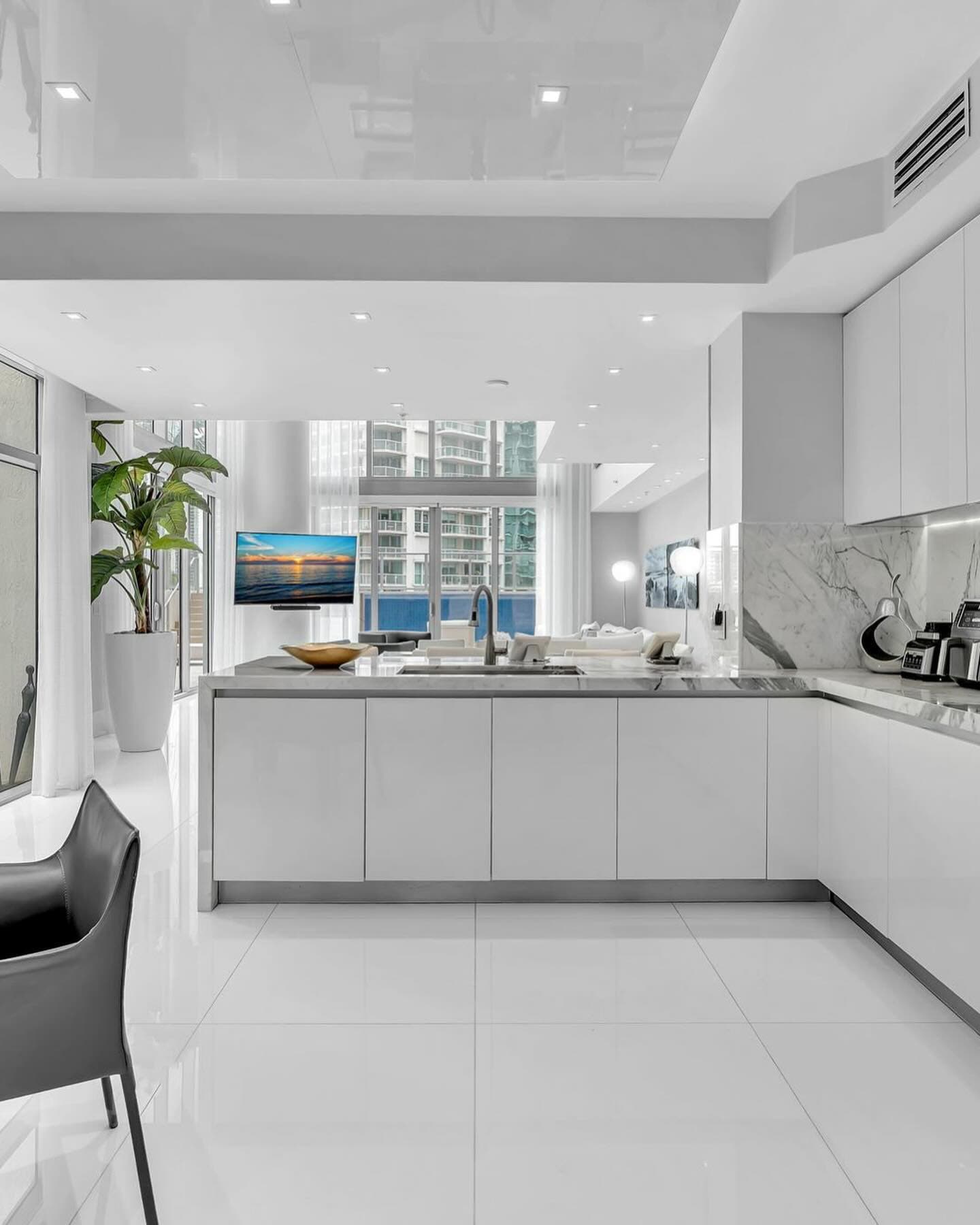 White gloss kitchen with an island and city view